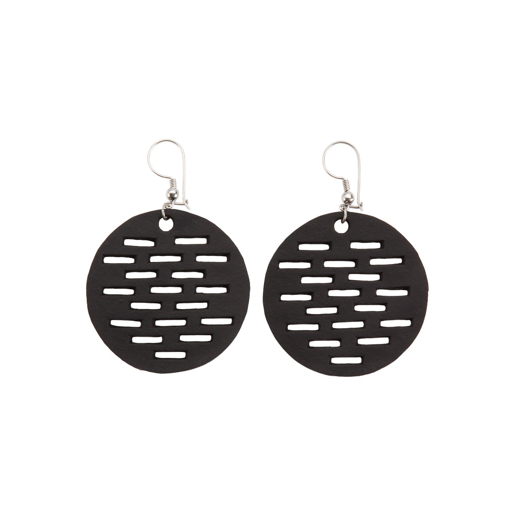 Paguro Upcycle black circular recycled rubber earrings with horizontal cutouts and silver hooks