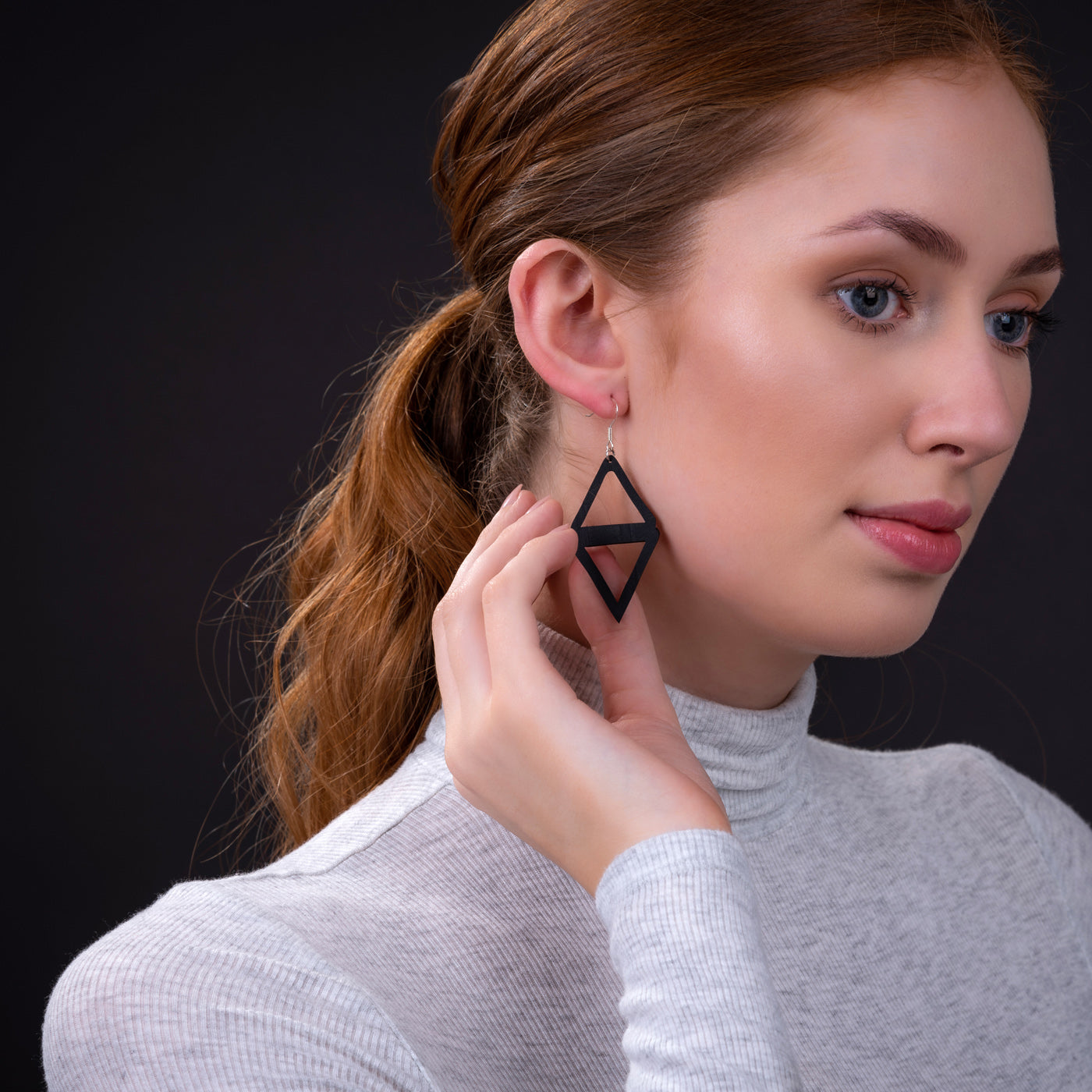 Paguro Upcycle recycled rubber earrings black geometric diamond drop with hook on model wearing gray turtleneck