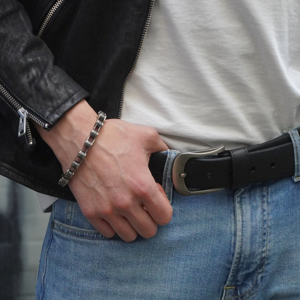 Stylish black recycled motorbike Tyre Rubber belt worn with denim jeans and a leather jacket