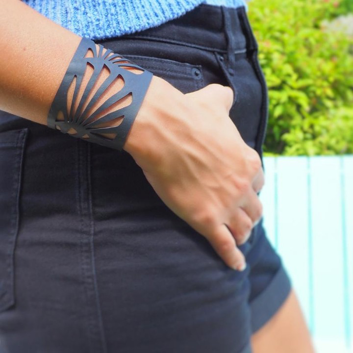 Paguro Upcycle recycled rubber bracelet black laser cut cuff worn on wrist with casual shorts outfit