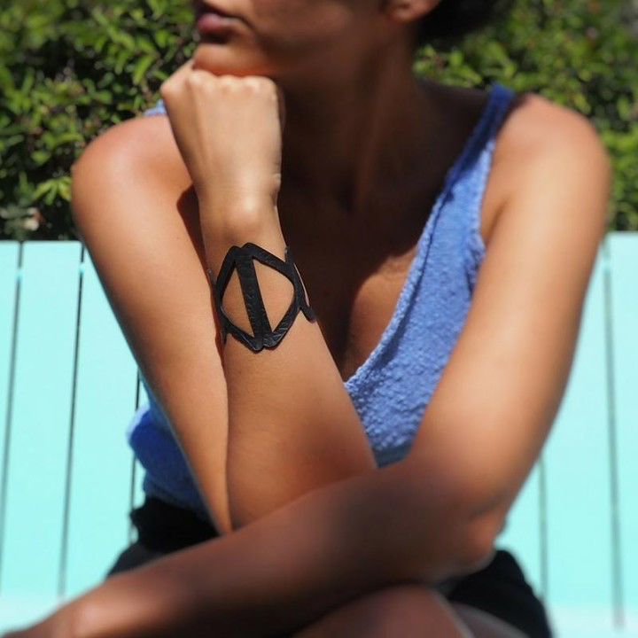 Paguro Upcycle black geometric cuff recycled rubber bracelet worn on female forearm outdoors