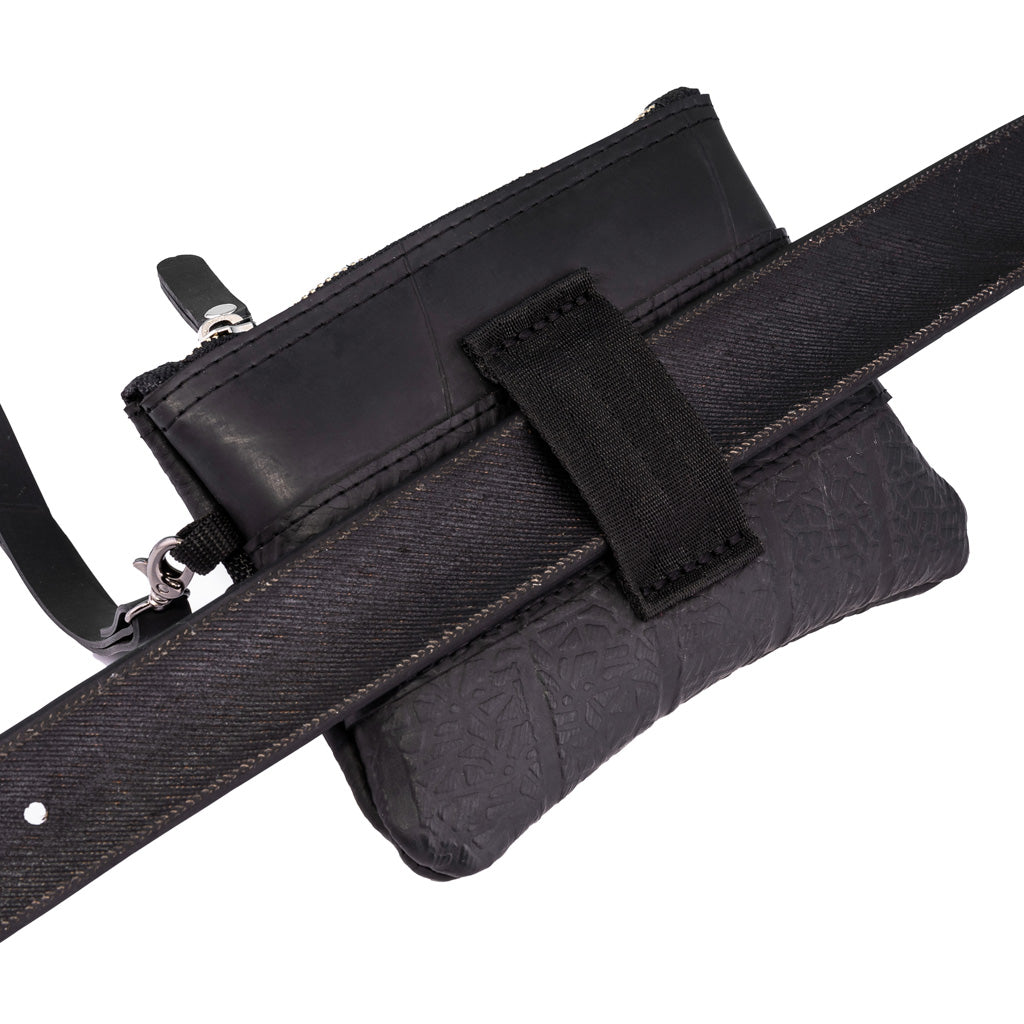 Paguro Upcycle black vegan wristlet pouch with textured design and zipper closure attached to a belt
